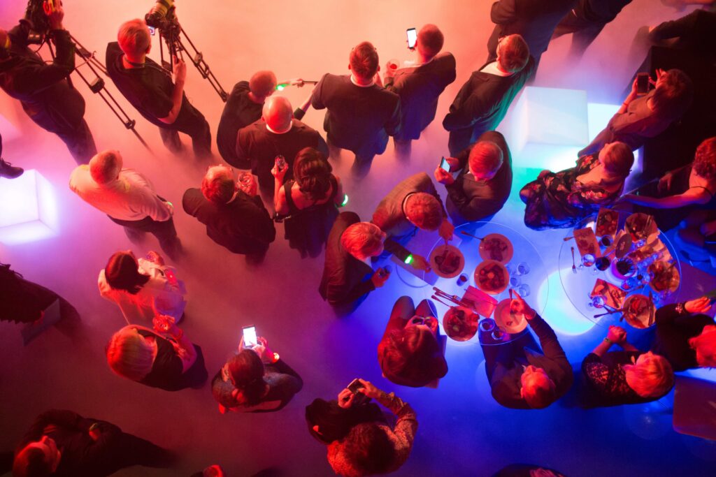 Aerial view of attendees engaged in conversations at an event, representing effective planning and coordination from an event management checklist.