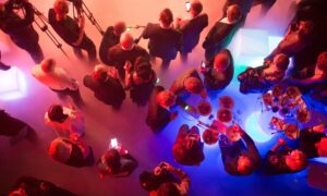 Aerial view of attendees engaged in conversations at an event, representing effective planning and coordination from an event management checklist.