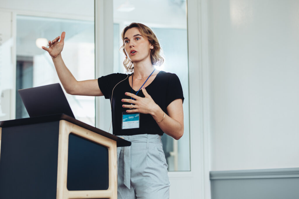 Young speaker passionately addressing a crowd, actively engaging the audience during a live event.