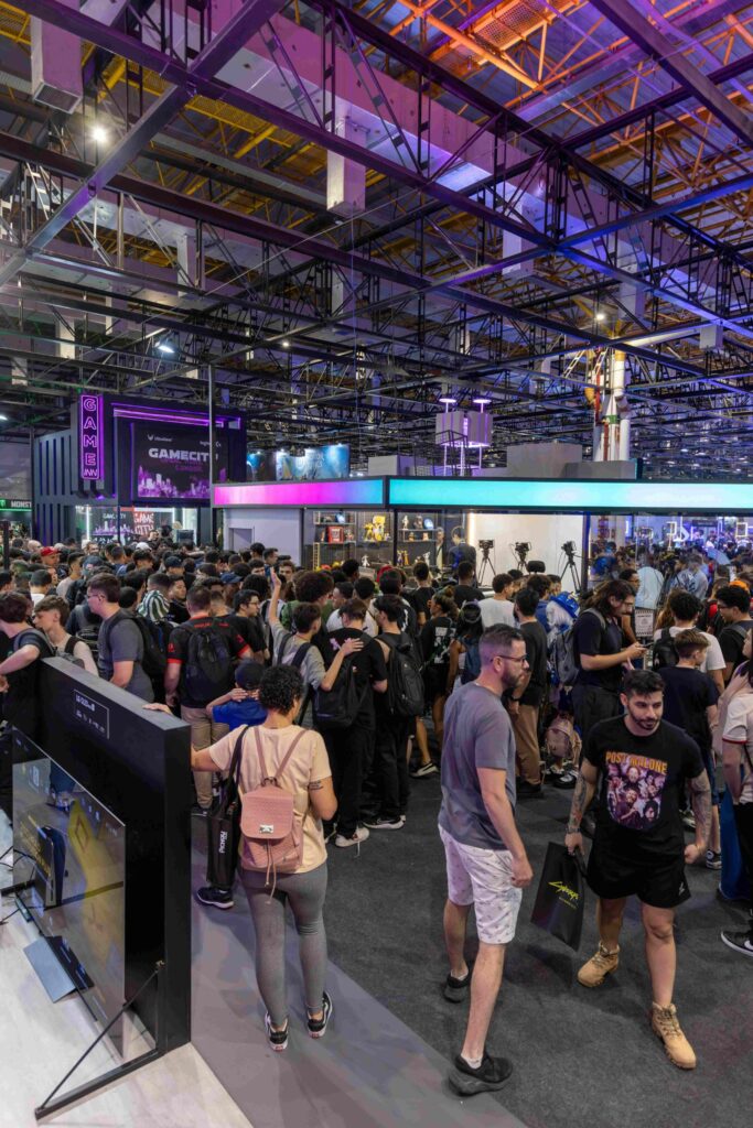 A large-scale brand activation at a convention, showcasing multiple interactive booths, immersive displays, and a high-energy crowd