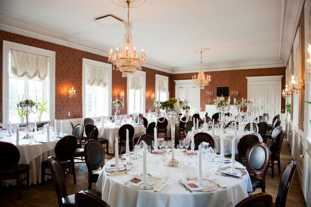 Elegant event venue dining room with round tables beautifully laid for a formal occasion.