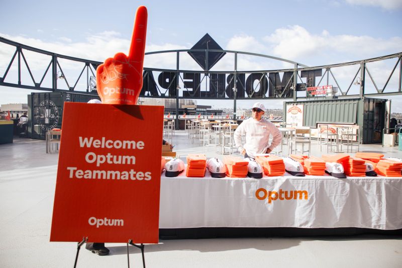 Optum brand activation featuring branded merchandise and vibrant signage, set up to attract and engage attendees.