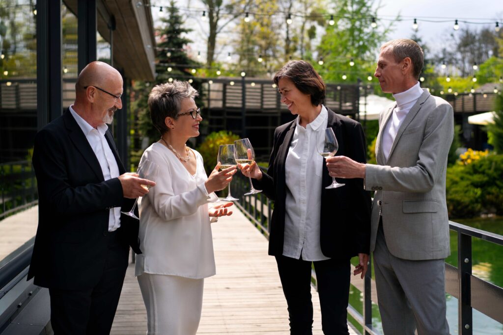 Senior and younger attendees engaged in friendly conversation at an event, fostering intergenerational connection.
