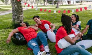 Team laughing together on grass during a corporate team bonding activity
