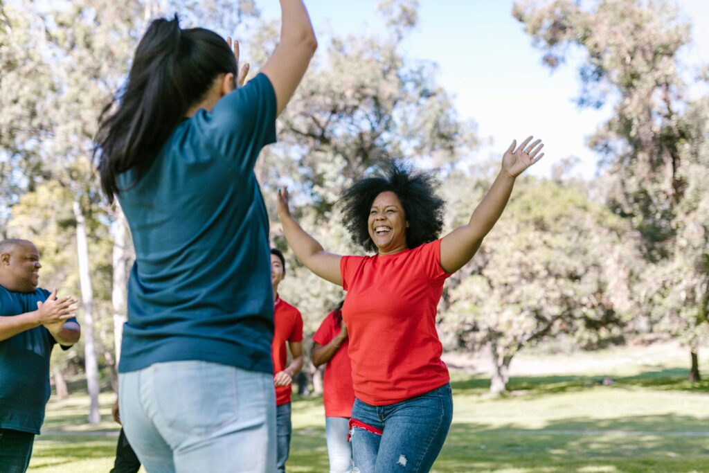 Two colleagues celebrating success during an outdoor team building activity, illustrating why team building is important for collaboration and morale