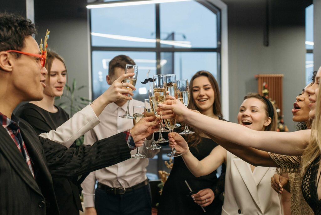 Employees raising glasses and cheering together at a festive corporate Christmas party.