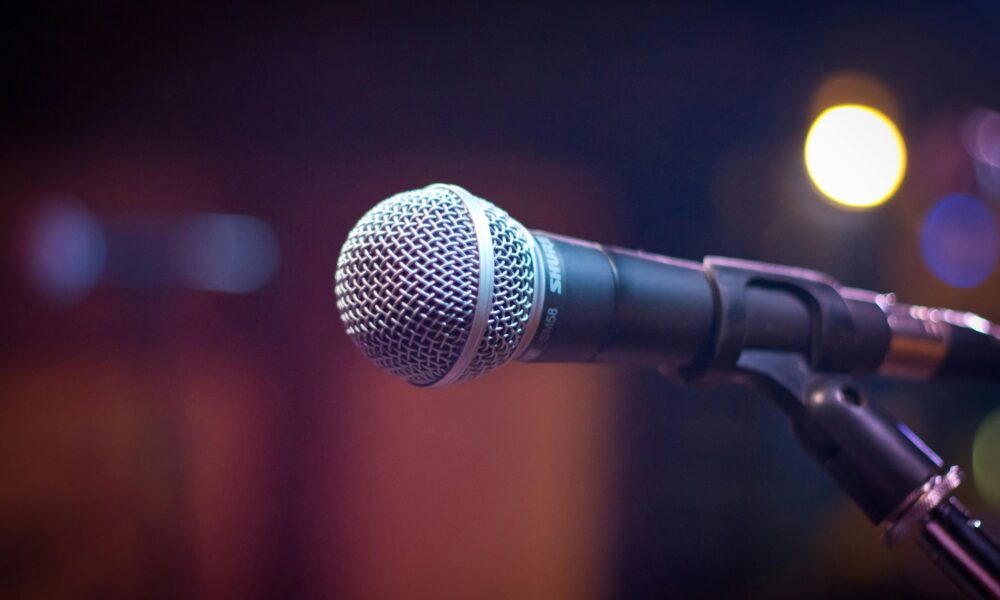 Close-up of a microphone on a stage, symbolising public speaking and presentation skills.