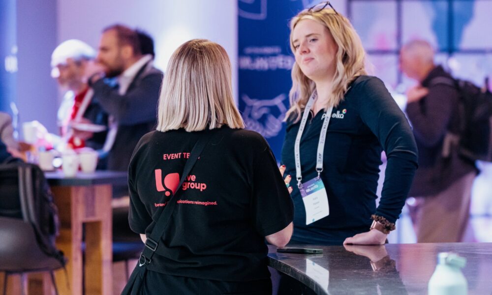 Live Group event manager overseeing on-site event management during a live event, representing a leading event agency.