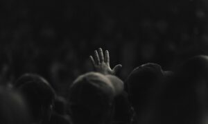 Event audience member raising hand, symbolising successful event personalisation and audience engagement