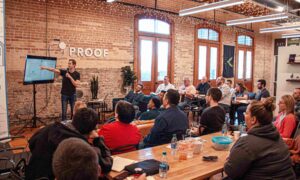 Speaker delivering a live product demo at an event, using branded visuals to drive events brand awareness and strengthen brand credibility