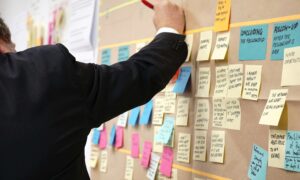A communication planning board covered in colourful sticky notes, organised into sections for strategy, messaging, timelines, and tasks, showing a collaborative approach to campaign or internal communications planning.