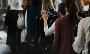 Employee raising hand to ask a question during a town hall meeting discussion