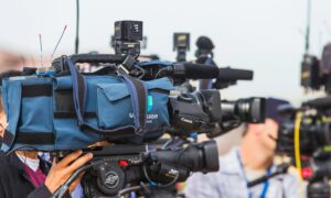 Camera crew filming a media launch event.