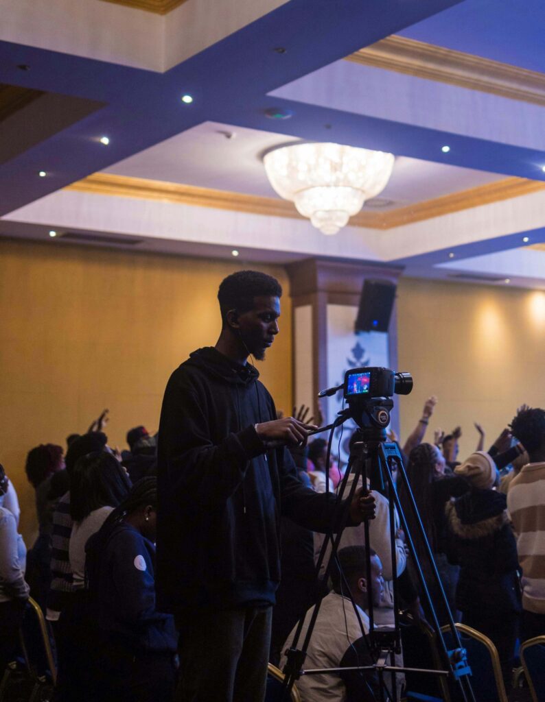 Camera operator filming at a media launch event.