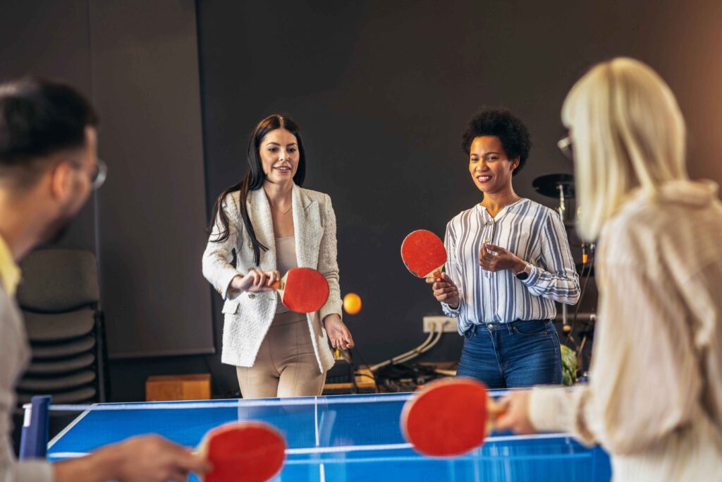 Team playing table tennis at corporate sports day