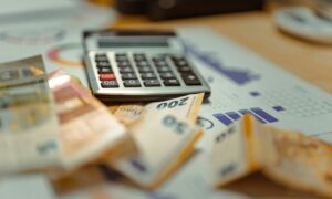 Calculator and money to demonstrate event cost and budget.