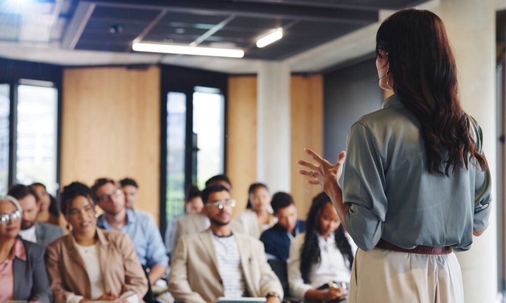 A woman delivering a corporate workshop to delegates.
